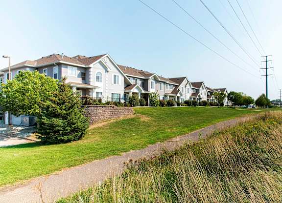 A row of houses with a grassy area in front.