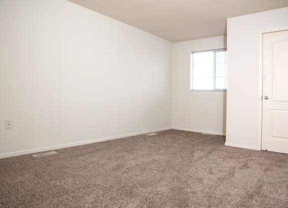 an empty room with carpet and a door