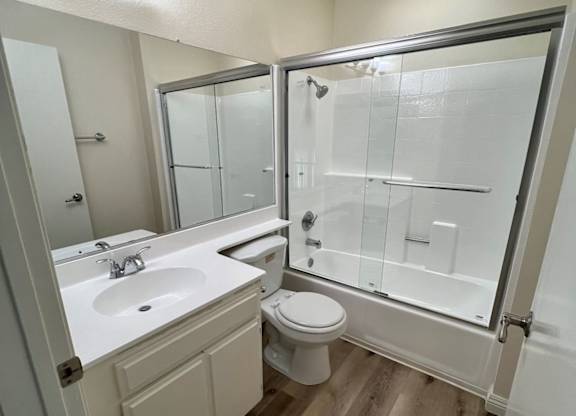 A bathroom with a toilet, sink, and shower.