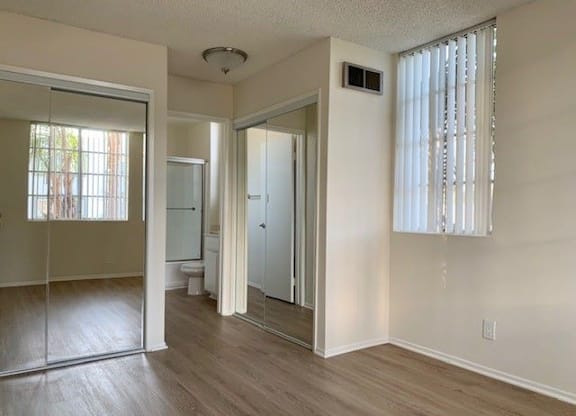 A room with a sliding glass door and a white door.