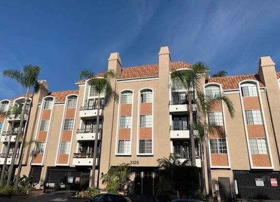 The castle heights apartment building with a balcony and a black gate in front.