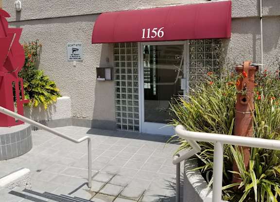 A red sculpture in front of the leasing building and the number 1156.