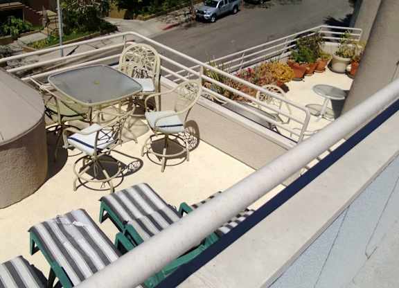 A patio with a table and chairs is seen from above.