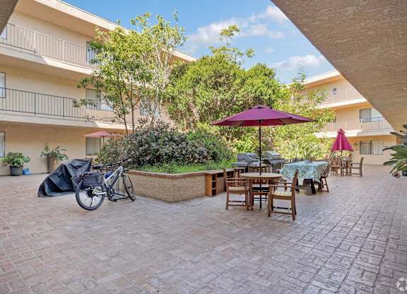A patio with a table and chairs and a bicycle.