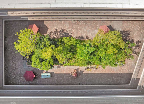 A small garden with a bench and a table surrounded by a brick wall.