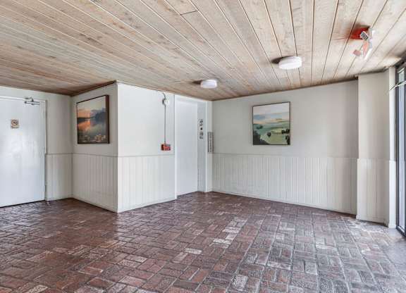 A room with a wooden ceiling and a brick floor.