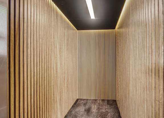 A wooden panel elevator with a light on the ceiling.