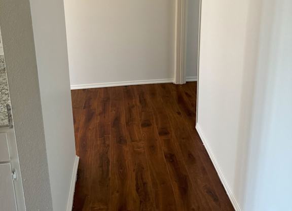 A room with a wooden floor and white walls.