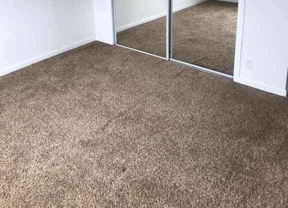 A room with a carpeted floor and a sliding glass door.