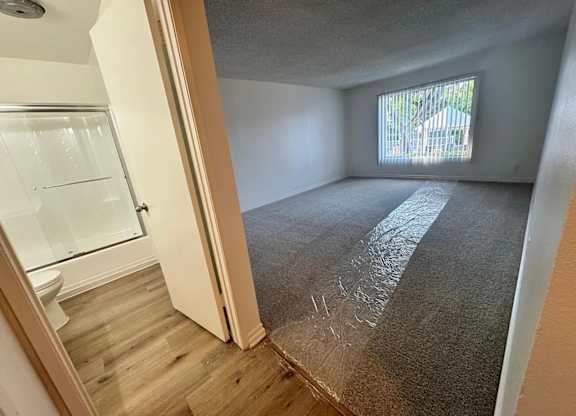 A room with a carpeted floor and a window.