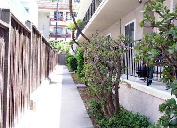 A narrow sidewalk runs between two buildings.