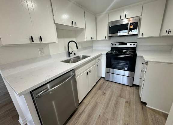 A kitchen with white cabinets and a black oven.