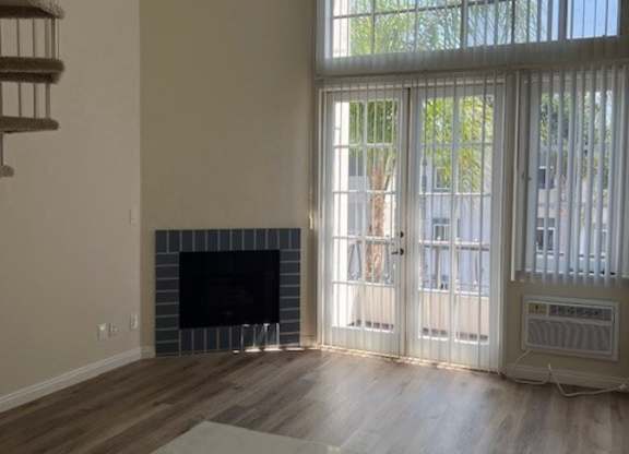 A room with a fireplace and sliding glass doors.