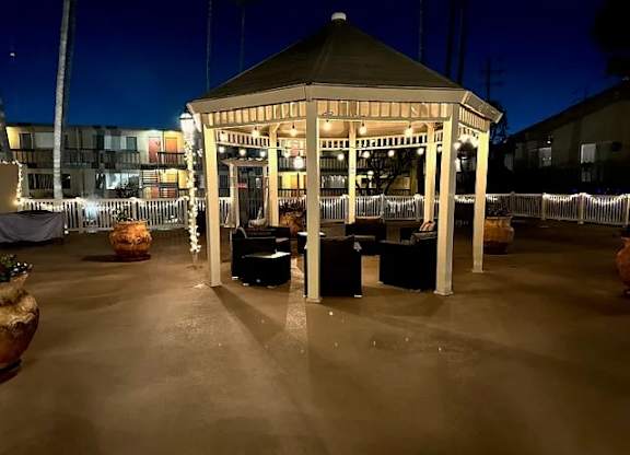 A gazebo is lit up at night with lights on the ground.