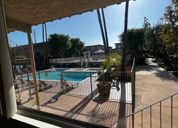 A pool area with a fence and a patio table.