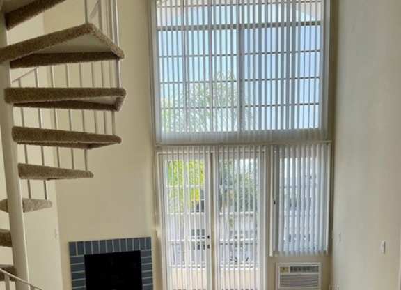 A living room with a fireplace and a staircase.