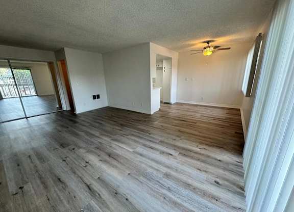 A room with wooden flooring and a ceiling fan.