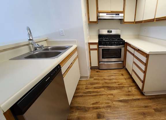 A kitchen with wooden floors and white walls.