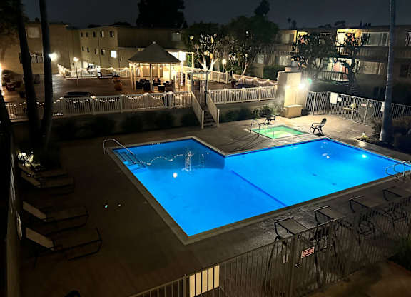 A pool at night with lights on.