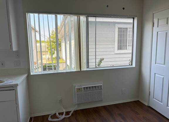 A room with a window and a white wall.
