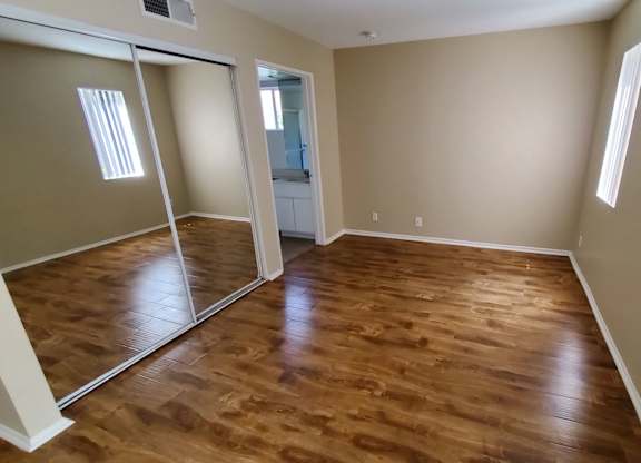 A room with wooden flooring and a sliding door.