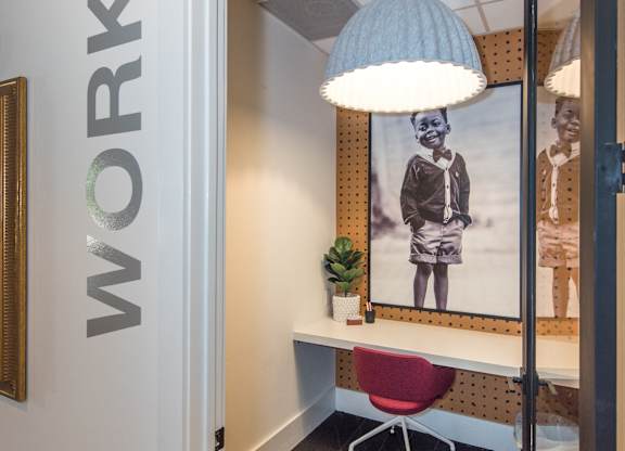 a room with a desk and a lamp and a picture on the wall