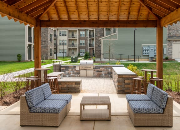 a covered patio with wicker furniture and a fire pit at The Whitworth, Williamsburg, Virginia