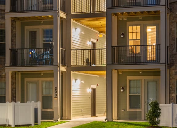 an apartment building at night with a green lawn in front of it at The Whitworth, Williamsburg, VA, 23185