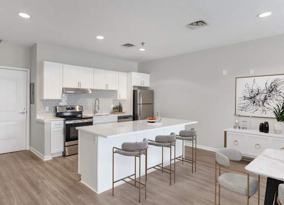 an open kitchen and dining area with a white island and stools
