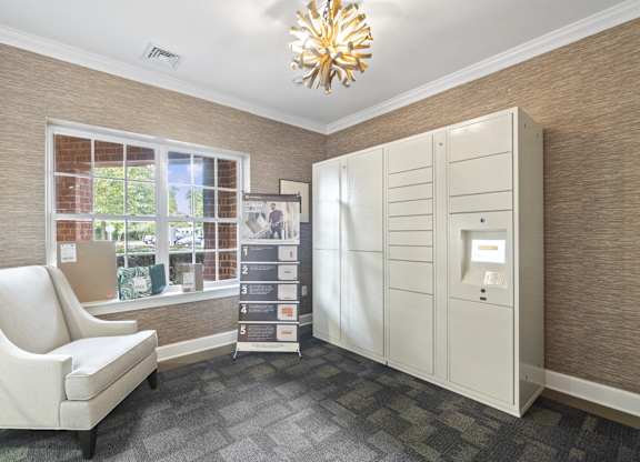 the living room has a large window and a white dresser with a white chair