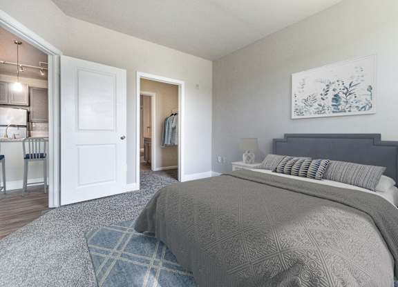 A bedroom with a large bed and a painting on the wall.