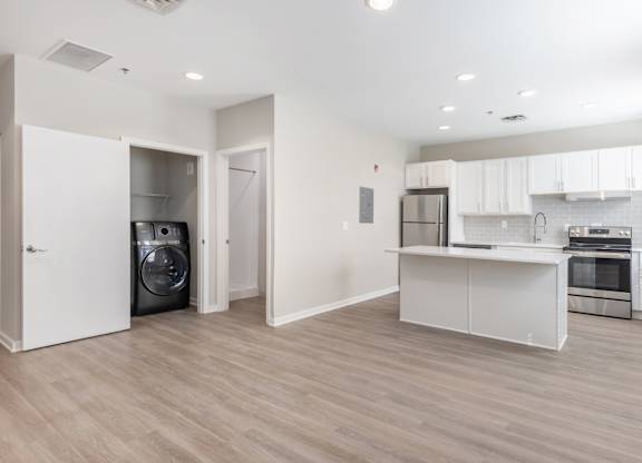 A modern kitchen with a washer and dryer in the laundry room.