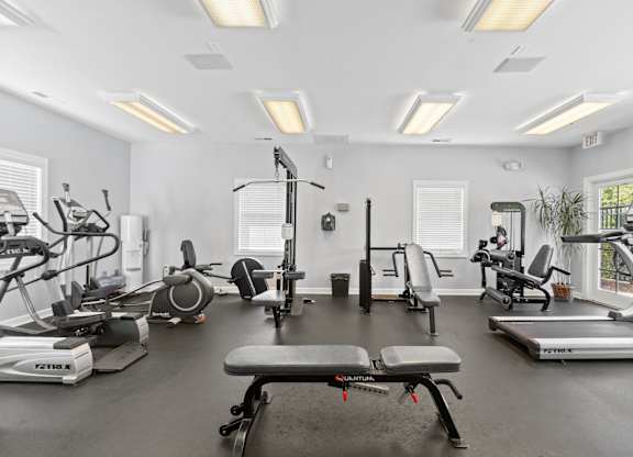 a gym with treadmills and other exercise equipment and windows