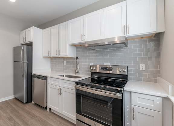 A kitchen with white cabinets and a black stove top oven.