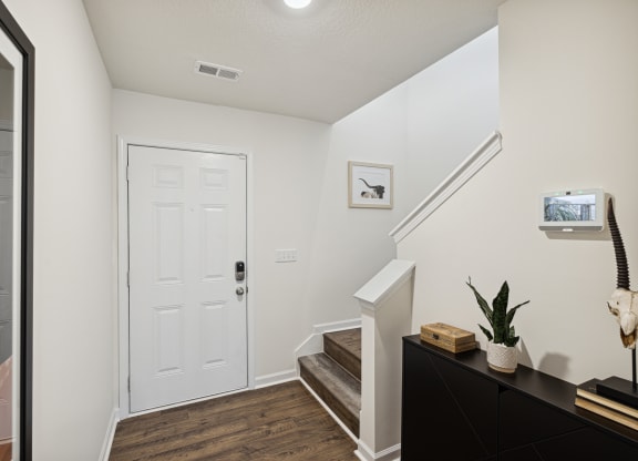 an entryway with stairs and a white door and a stairwell with a plant at Summit Place Apartments, Oak Ridge