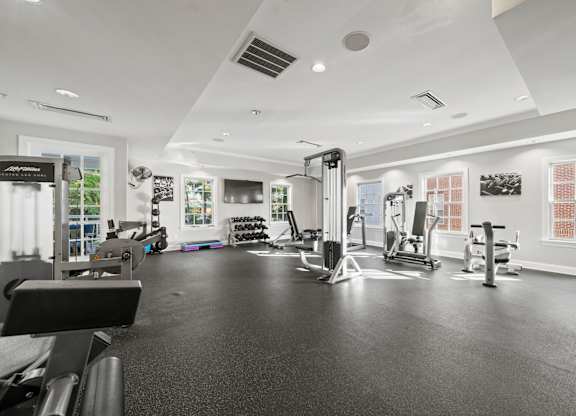 A black and white photo of a gym with various exercise equipment.