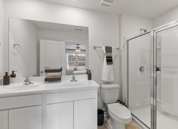 a white bathroom with a shower and a sink and a toilet at Summit Place Apartments, Oak Ridge, Tennessee
