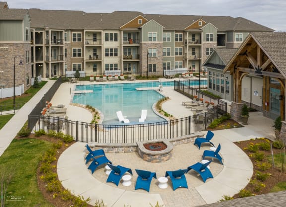 an outdoor pool with lounge chairs and fire pit at The Whitworth, Williamsburg, VA, 23185