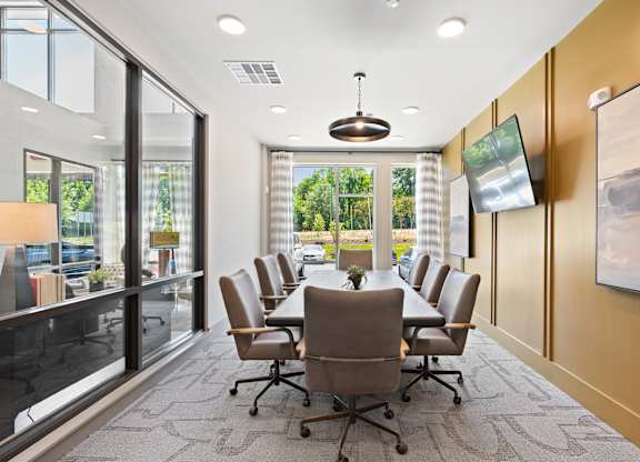 A conference room with a long table and chairs.