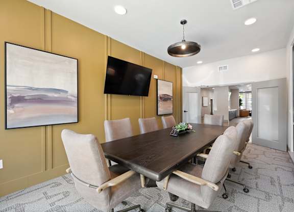 A conference room with a long table and chairs.