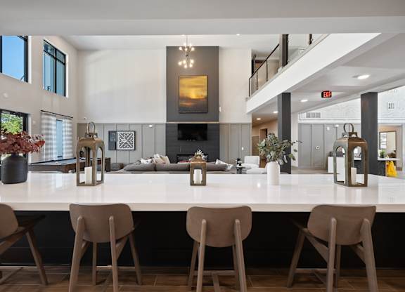 A modern kitchen with a long island and chairs.
