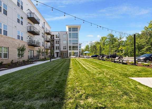 A long grassy area with apartment buildings on either side.