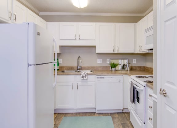 a kitchen with white cabinets and appliances and a refrigerator at Abbington Place Apartments, North Carolina