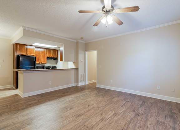 A room with a ceiling fan and wooden flooring.