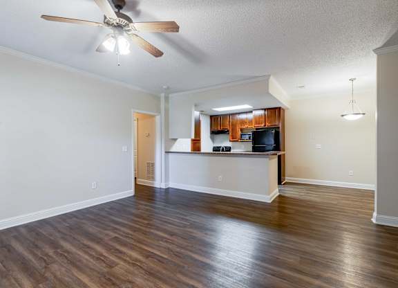 A room with a ceiling fan and wooden flooring.