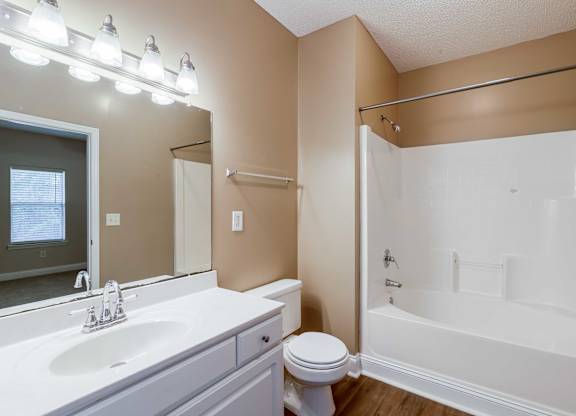 A white toilet sits next to a sink in a bathroom.