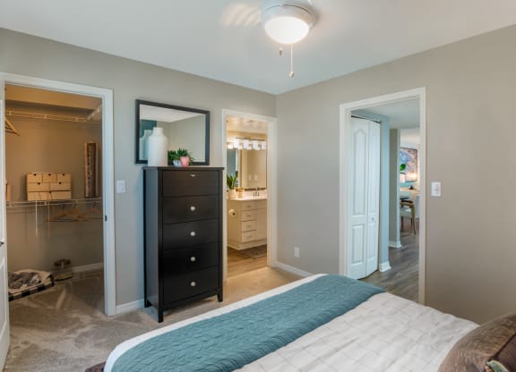 a bedroom with a bed and a dresser and a bathroom at The Villas at Ibis Landing, Parkland