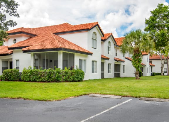 a white house with a yard and a palm tree at The Villas at Ibis Landing, Parkland, 33067
