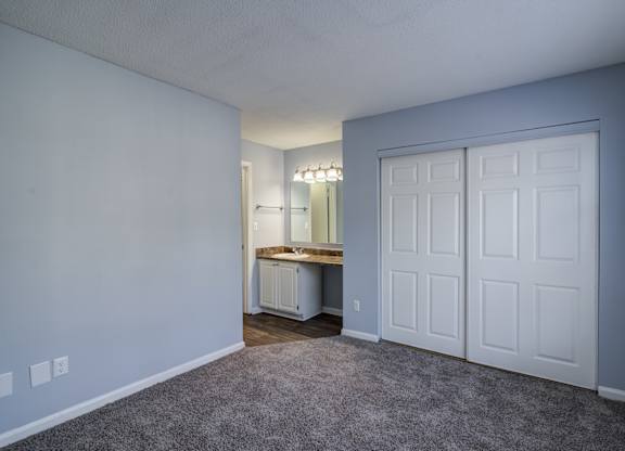 A room with a white door and a vanity with a mirror.