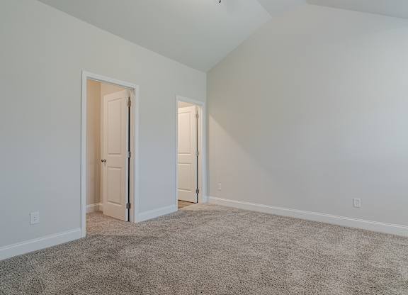 A room with two doors and carpeted floor.